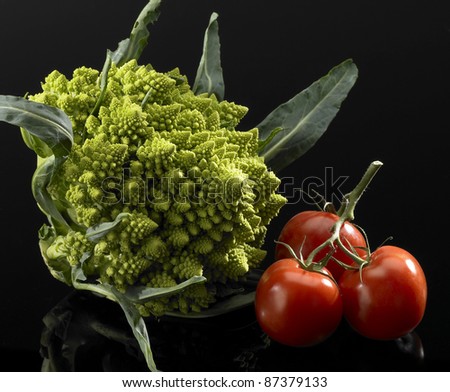 green cauliflower and red tomatoes in black back