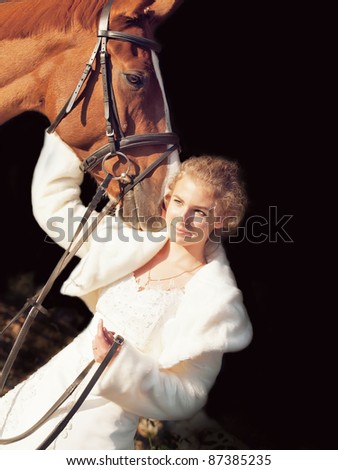 nice bride with  her horse at dark background