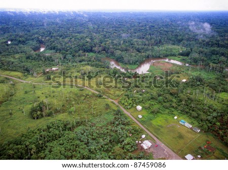 Amazonian rainforest in Ecuador, road foreground bringing colonists who have cut down the forest, but with primary forest beyond the river in the background