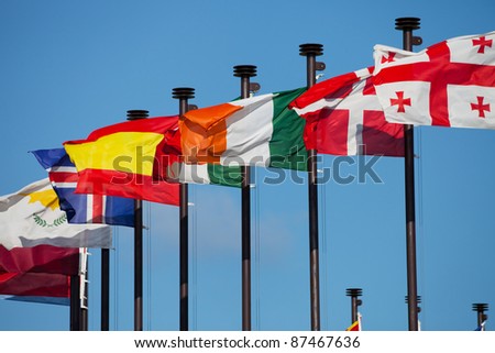 Flags of different countries are developing on the flagpoles