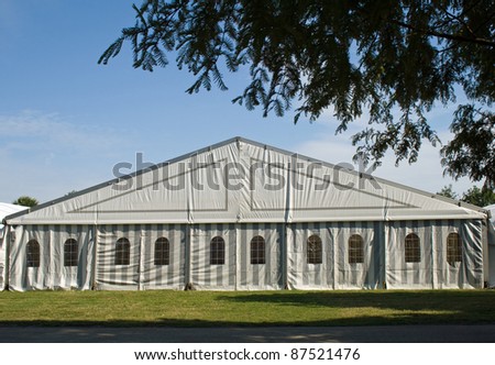 A white party or event tent on a meadow in a public park Royalty-Free Stock Photo #87521476