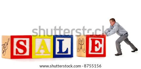 Man pushing a big "E" to complete a SALE sign made of oversized alphabet blocks.