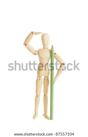 Wooden figure holding green pencil and looking