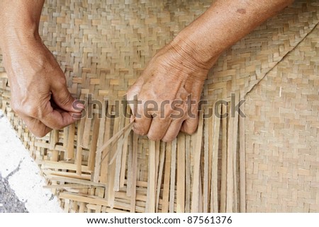 Thai woman hands weaving reed mat Royalty-Free Stock Photo #87561376