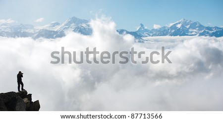 photographer taking picture of Swiss Alps, peak of Matterhorn on the horizon, Switzerland
