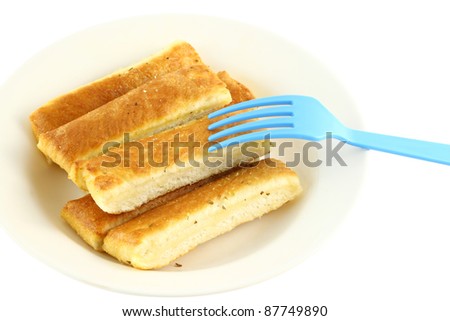 Bread stick in white disk with blue plastic fork.