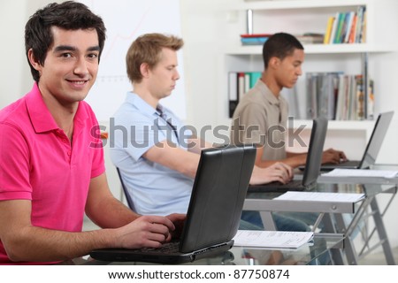 Young men working on their assignments in a computer lab Royalty-Free Stock Photo #87750874