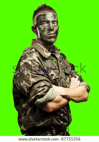 portrait of young soldier painted with jungle camouflage against a removable chroma key background