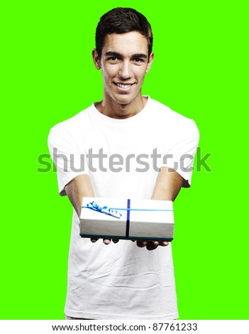 portrait of young man giving a gift against a removable chroma key background