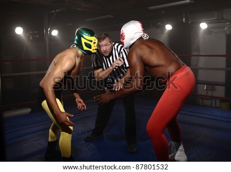 Two masked wrestlers prepare to fight