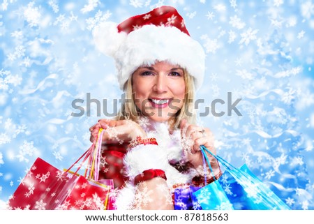 Beautiful santa woman with shopping bags. Christmas background.