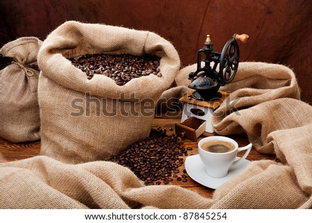 Studio photo of sack with scattered coffee grain, and cup of espresso