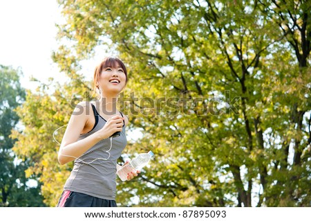attractive asian woman running in the park Royalty-Free Stock Photo #87895093
