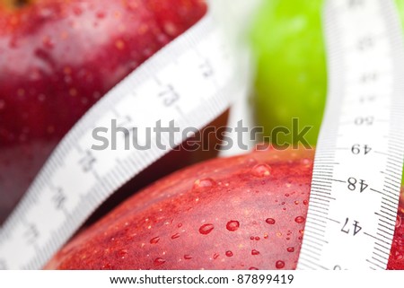 apple with water drops and measure tape isolated on white
