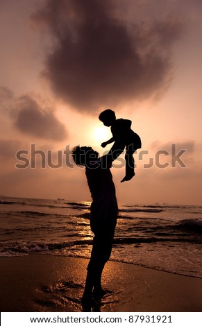 the silhouette of happy father and little girl on the beach