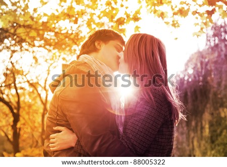 Couple kissing in the park at sunset. Photo in multicolor image style.