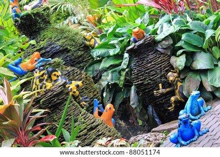 Colorful ceramic frogs and mini pottery fountain decorating at the tropical garden, Thailand