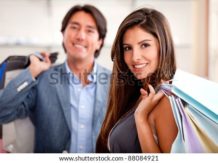 Beautiful shopping couple at a store holding bags and smiling