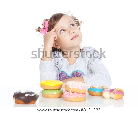 Picture of funny little girl with donuts looking up on white background
