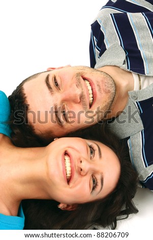 A young couple lying, looking at each other, isolated on white background