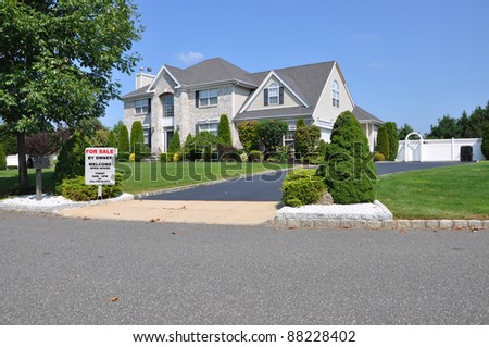 For Sale By Owner Sign on Landscaped Front Yard of Suburban Home in Residential Neighborhood