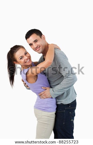 Young couple hugging each other against a white background