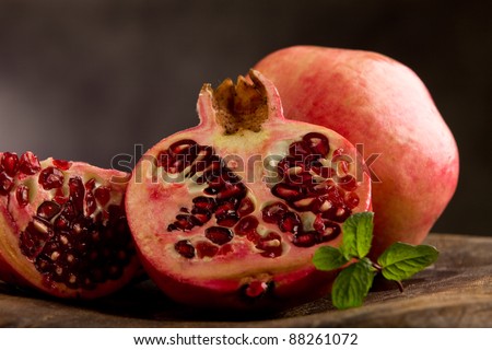 photo of sliced pomegranate in poor art style in front of rural background