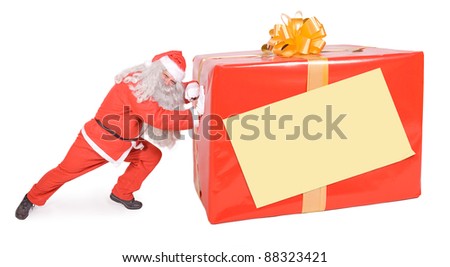 Santa Claus pushing large Christmas box isolated on white background. Big Xmas gift with empty sign on the packaging.