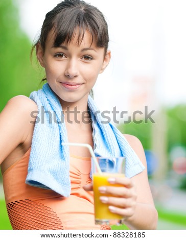 Teenage girl drinking orange juice after fitness exercise