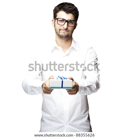 portrait of a handsome young man showing a gift over a white background