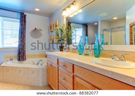 Blue bathroom with large tub and double sink cabinet
