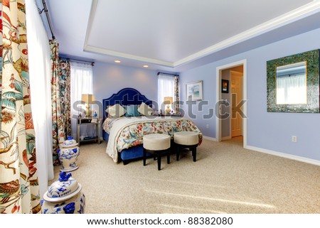 Blue luxury bedroom with many windows and curtains