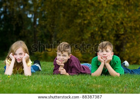 A group of children laying down in the grass.