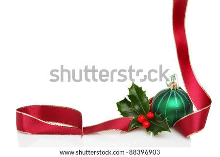 Christmas border or frame of red ribbon, green glass bauble and fresh holly leaves with berries, white copy space