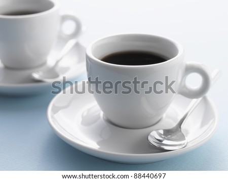 Two cups of coffee on blue background