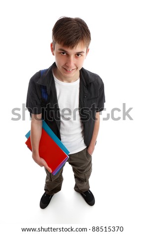 A male teenage student standing in casual clothes and holding some books in one hand.  White background.