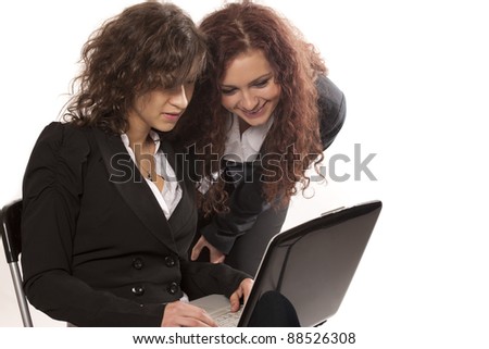 Two smiling businesswomen working on a laptop