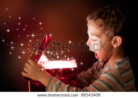 A surprised child opening and looking inside a magic gift