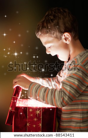A surprised child opening and looking inside a magic gift