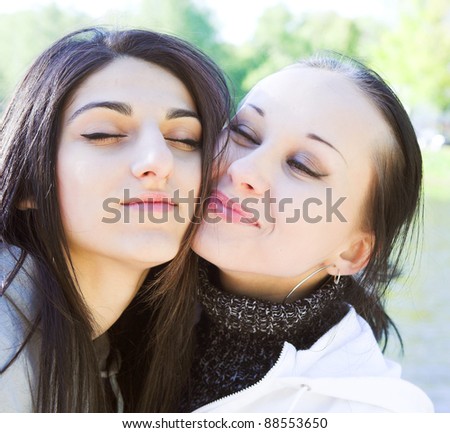 Two young women by the lake having fun