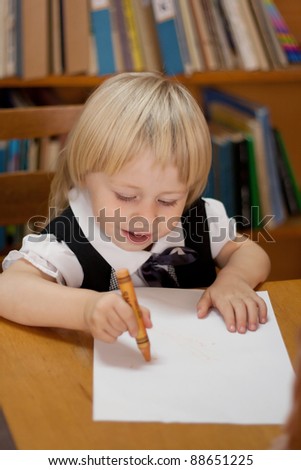 little girl drawing on a white sheet in the library