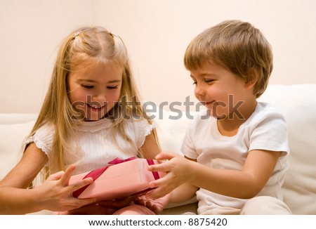 Little boy make a present to his sister