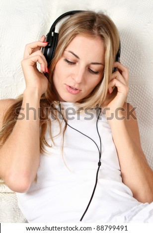 Portrait of the blond beauty smiling girl wearing headphones