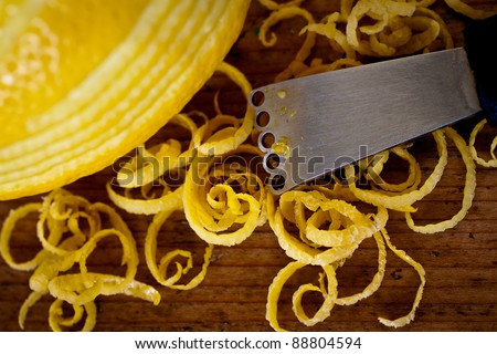 Peeling lemon rind to add zest to Mediterranean recipes. Selective focus. Royalty-Free Stock Photo #88804594
