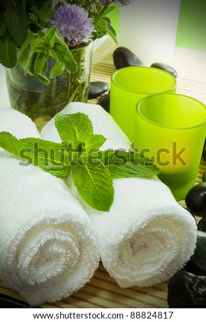 Warm towels, candles, herbs and zen stones for a spa treatment.