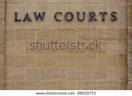 Law courts sign on an old stone wall with copy space. Law courts sign.