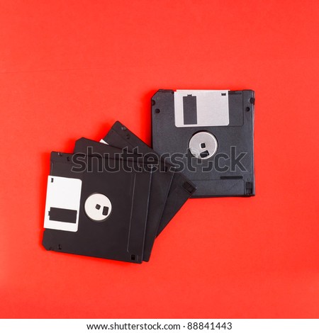 floppy disk magnetic computer data storage support on a red background