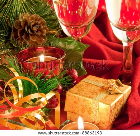 Christmas card. Champagne, a branch of a fur-tree and a candle on a red background