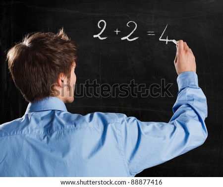 Man writing a simple formula on a blackboard