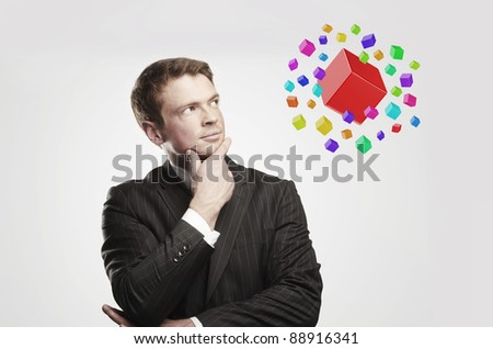 Young  businessman with colored boxes. On a gray background